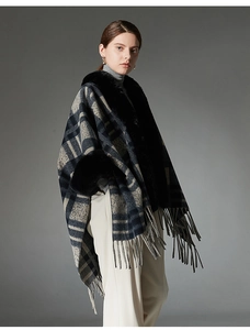 Detail of grey plaid shawl with black faux fur collar and fringe tassels for autumn