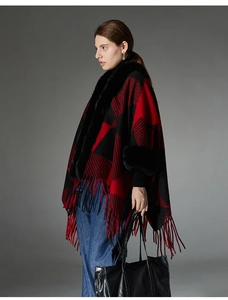 Detail view of red plaid shawl featuring thick faux fur collar and long fringe tassels