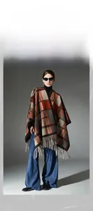 Detail of wool fringe shawl with camel checkered pattern on urban casual model
