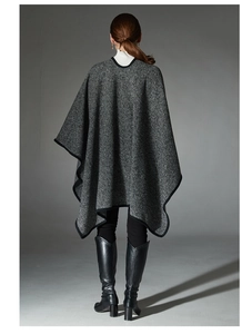 Back view of a grey striped poncho shawl featuring black ribbon edges and a draped silhouette