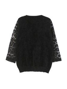 Detailed view of the black knit sweater featuring intricate lace sleeve patchwork