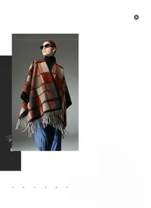 Detail of vintage plaid poncho with orange and grey check pattern and tassel fringe