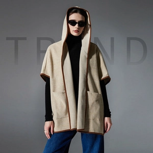Detail of hooded knit poncho vest with contrast trim and large front pockets