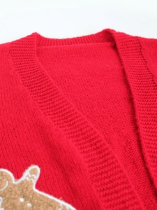 Close-up of red knit cardigan featuring detailed gingerbread man embroidery