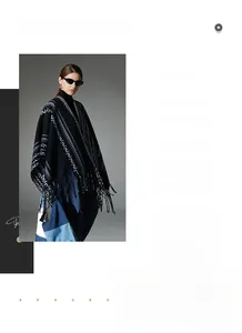 Detail of dark blue knit poncho with Nordic geometric patterns and black fringed hem