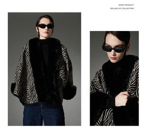Detail of zebra pattern shawl with luxurious black faux fur collar and cuffs on model