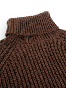 Nahaufnahme der dicken dunkelbraunen Stricktextur und des hohen Rollkragenpullovers
