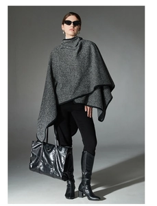 Detailed close-up of high-neck striped knit shawl wrap with irregular hem and black piping
