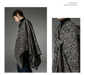 Detail view of a thick knit zebra print shawl featuring premium texture and black trim