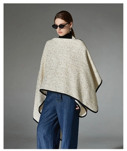 Detailed view of tweed wool shawl with gold thread texture and black piping trim