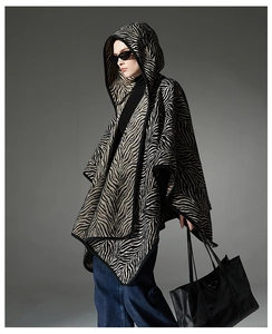 Détail d'une cape à capuche à motif zébré noir et blanc avec une texture tricotée épaisse