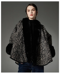 Detailed view of the zebra pattern texture and fluffy black faux fur collar on the cape