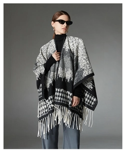 Detail of wool blend cape with houndstooth pattern and white long tassel fringe