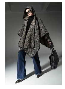 Détail du poncho en maille à capuche avec motif zébré noir et blanc et bordure soignée