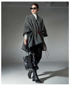 Detail of striped cape coat featuring black edge trim and a brown decorative waist belt