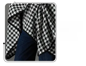 Detail of classic houndstooth shawl featuring refined black piped edges and tweed texture