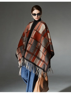 Detailed close-up of camel plaid wool shawl with long fringes and thick knit texture