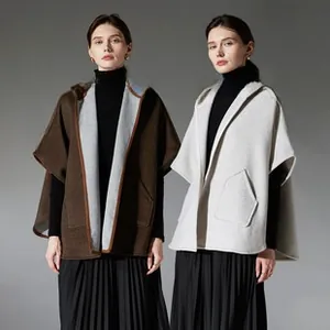 Detail of hooded cape shawl with large pockets and contrast stitching in camel and beige