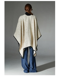 Rear view of an elegant cream tweed cape with black contrast trim for women