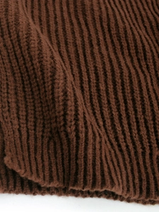 Detaillierte Makroansicht des dunkelbraunen Rippstrickgewebes für langärmelige Pullover