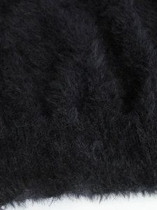 Close-up of premium black lace-trimmed faux fur fabric with dense and fluffy texture
