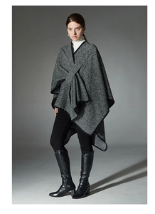 Detail of the black and white striped knit shawl featuring a stylish buckle and draped collar