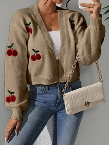 Detailed view of 3D cherry embroidery on a khaki knit cardigan with ribbed cuffs
