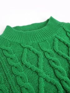 Detailed close-up of bright green cable knit texture and ribbed crew neck on dress