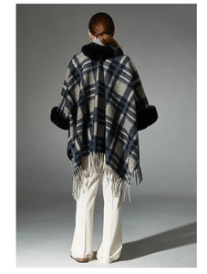 Rear view of a navy blue plaid poncho featuring thick faux fur trim and long tassel fringe