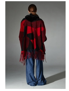 Back view of a red and black geometric plaid poncho with faux fur collar and tassels