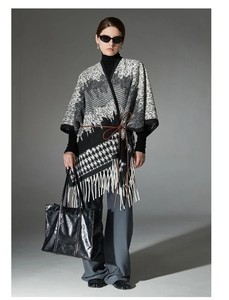 Detailed view of houndstooth wool shawl with fringe trim and brown leather waist belt