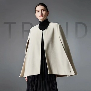 Detail of premium beige sleeveless cape coat showing its heavy wool texture and elegant slit