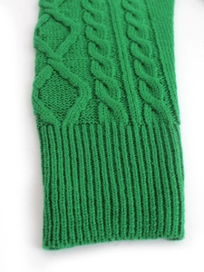 Detail of cable knit pattern and ribbed cuff on a bright emerald green sweater dress