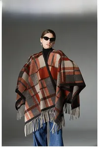 Detail of camel wool plaid shawl with fringe trim and stylish orange checkered pattern