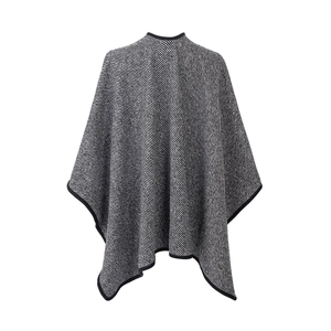 Detail of classic black and white striped knit cape with reinforced black edge piping