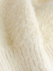 Detailed close-up showing the soft cream knit texture and fluffy faux mink fibers