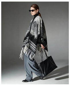 Detail of black and white houndstooth wool shawl featuring long white fringe tassels