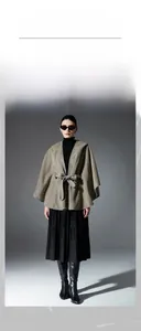 Detail view of double-sided solid color hooded poncho with waist belt and contrast edging