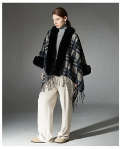 Detail view of navy plaid shawl jacket featuring thick faux fur collar and tassel hem design