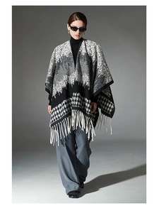 Detailed macro view of the knitted houndstooth pattern and soft fringes on the wool shawl