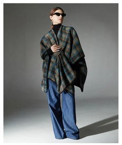 Detailed view of women's checkered shawl featuring blue, brown, and green plaid patterns
