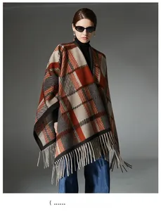 Detail of camel wool blend plaid poncho with long fringe tassels and large check pattern
