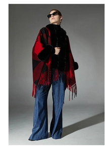 Detail of red buffalo plaid shawl featuring plush faux fur trim and fringed edges