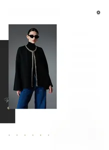 Close-up of black tweed cardigan with elegant gold braided trim and metallic button detail
