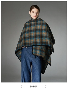 Detail of a thick plaid shawl poncho with blue and brown check patterns and black trim