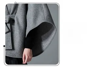 Detail of grey wool cloak featuring a delicate bow tie and premium stitching texture