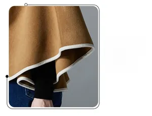 Detail of camel wool poncho showing white contrast piping and thick textured fabric