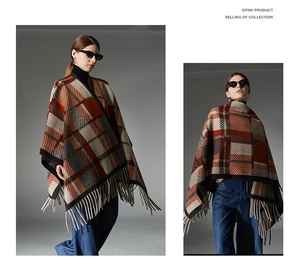 Detailed close-up of plaid poncho with classic red and beige patterns and tassel fringe