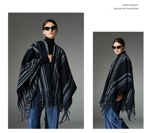 Close-up of navy knit poncho featuring white geometric jacquard patterns and long fringes
