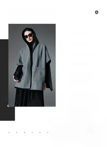 Detail view showing gray herringbone wool blend poncho with hood and black contrast piping